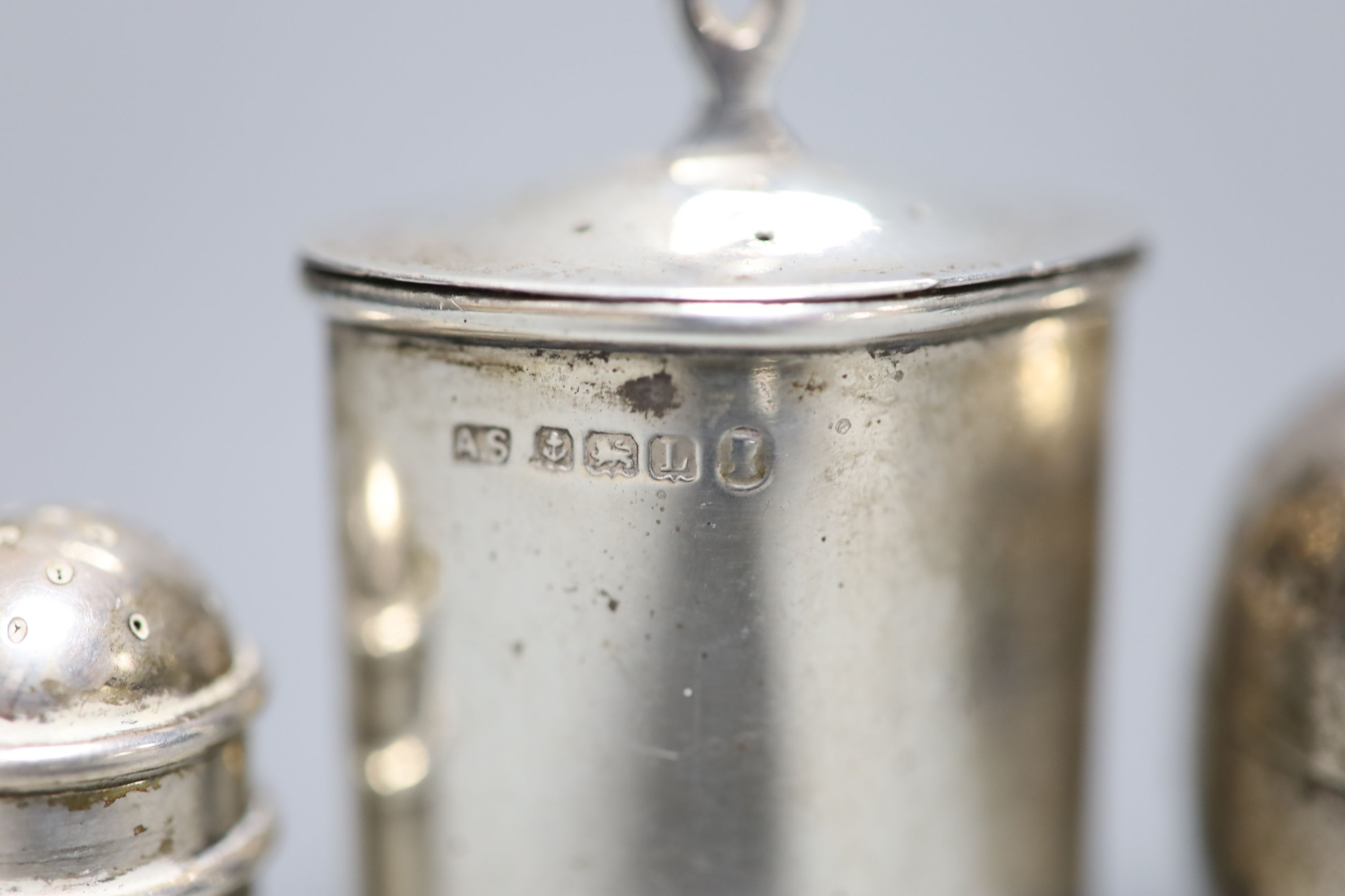 A pair of late Victorian small silver pepperettes, G.W. Harvey & Co, Birmingham, 1900, 35mm and two other silver pepperettes.